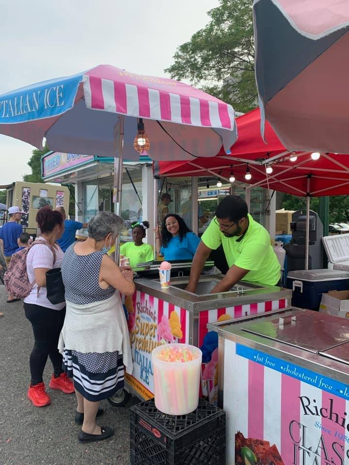 Richie's Italian Ice slush stand with pink and white striped umbrellas
